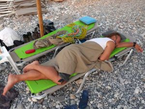 człowiek śpiący na leżaku na plaży
