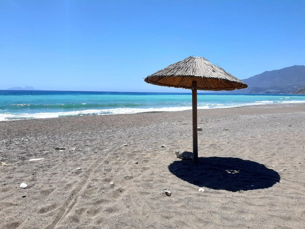 słomiany parasol na pustej plaży